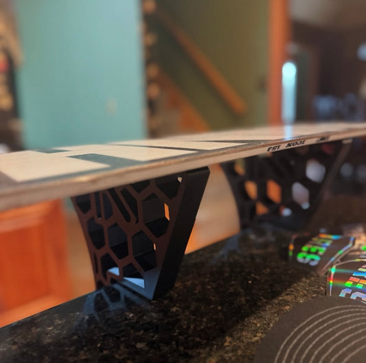 close up of a snowboard being tuned on Ares rand snowboard waxing stands