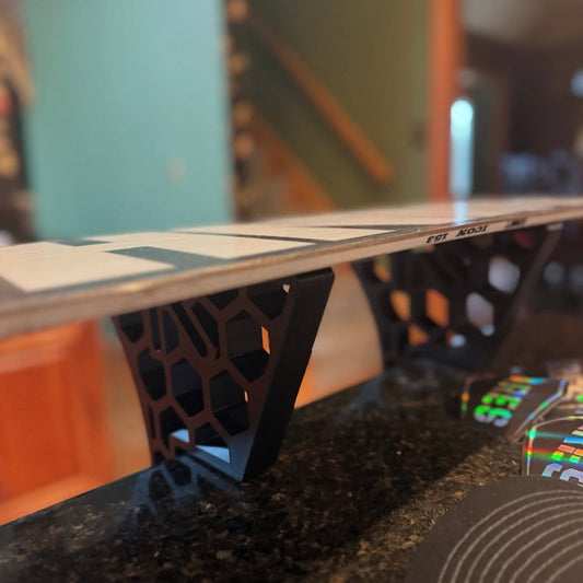 close up of a snowboard being tuned on Ares rand snowboard waxing stands