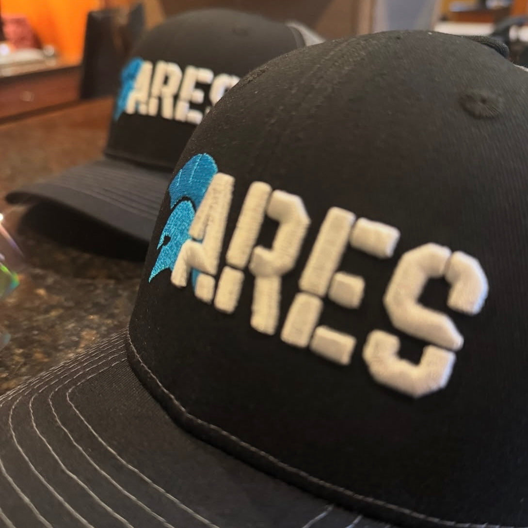 Two black caps with 'ARES' branding on a countertop